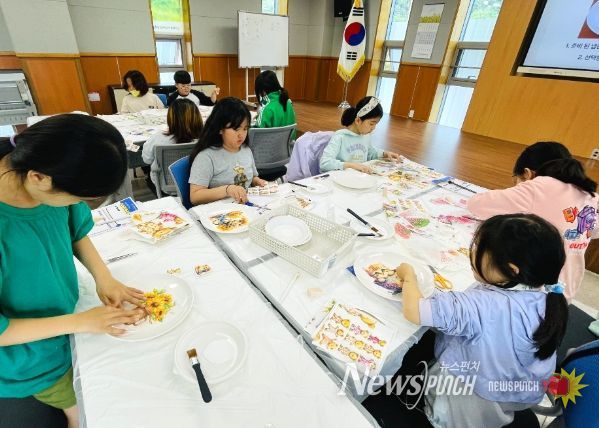 화려한 냅킨을 활용해 접시를 꾸미는 초등학생 참가자들
