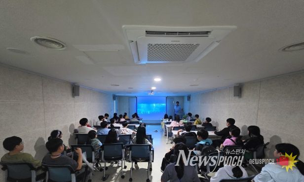 진로탐방 DAY 운영 사진(초빙 강사인 현직 아쿠아리스트가 학생들에게 아쿠아리스트의 역할과 아쿠아플라넷에 대해 설명하고 있다.)