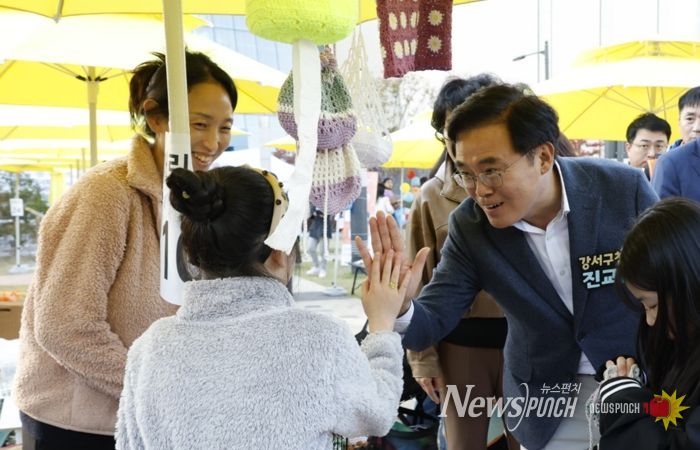 진교훈 서울 강서구청장(오른쪽)이 25일 발산근린공원에서 열린 ‘발산마을축제’에서 플리마켓에 참여한 아이와 손을 맞대고 있다.
