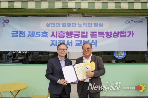 유성훈 금천구청장(왼쪽)과 김명식 상인회장이 골목형상점가 지정서 교부식을 진행하고 기념촬영을 하고 있다