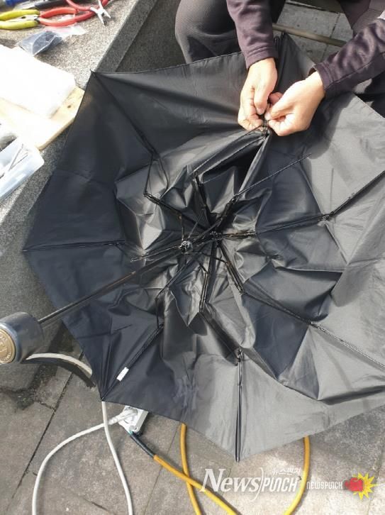 고장 난 우산을 수리하는 모습