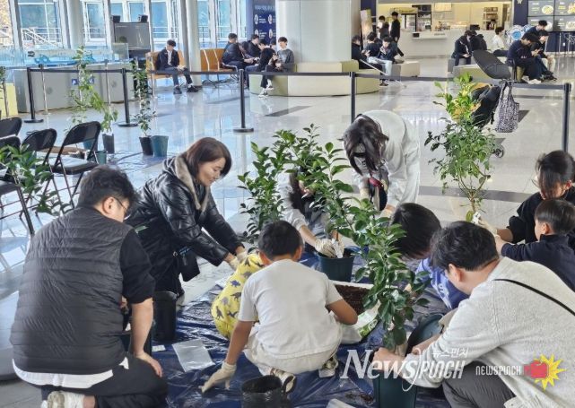 미래세대와 함께하는 ‘나는야 똑똑한 도시농부’ 교육현장(체험학습 참여가족이 우리나라에서 개발하고 보호등록된 감귤품종의 묘목을 심어보고 있다.)