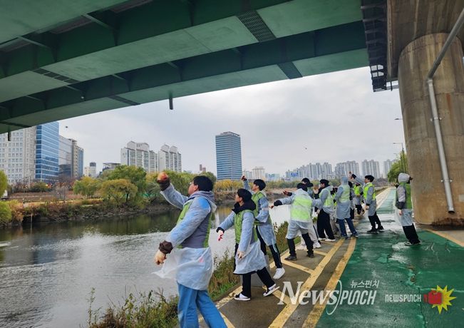 서울물재생시설공단‧환경실천연합회 직원들과 시민들이 친환경 정화 물질인 EM 흙공을 안양천에 던지고 있다.