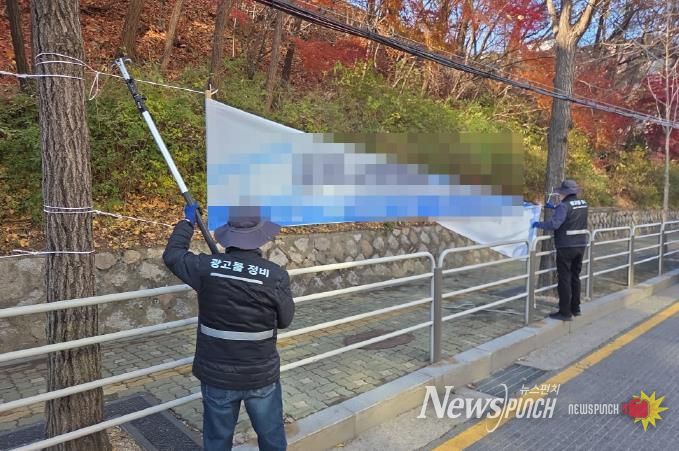 강북구 점검반이 불법 현수막을 정비하고 있다.