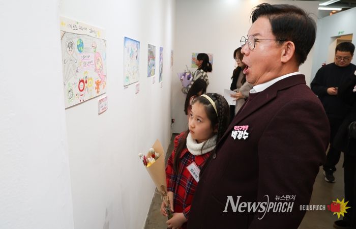 박강수 마포구청장이 수상 어린이와 함께 전시된 그림을 살펴보고 있다.