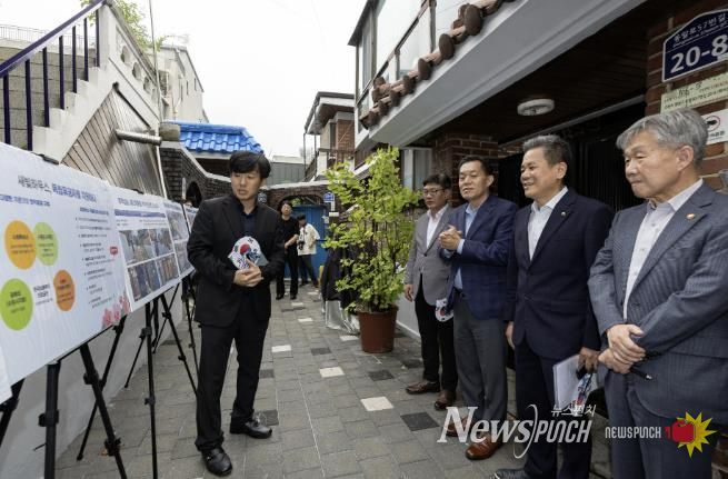 수원시와 한국보훈복지의료공단이 수원지역 독립유공자 후손의 집수리를 지원한 새빛하우스 앞에서 관계자들이 사업 설명을 듣고 있다.