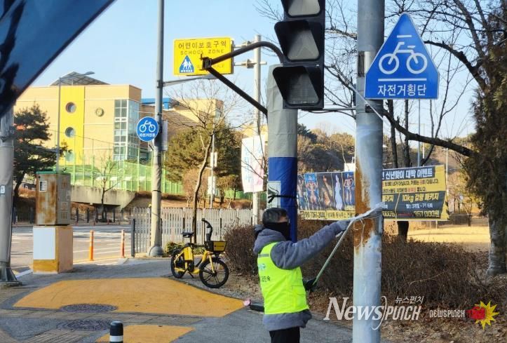 유성구청 직원이 어린이 보호구역 내의 불법광고물을 정비하고 있다