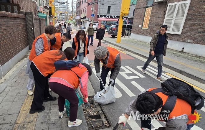 구로구소상공인연합회 회원들이 3월 31일 상권 일대에서 쓰레기 수거와 빗물받이 청소 등 환경정화 활동을 하고 있다.