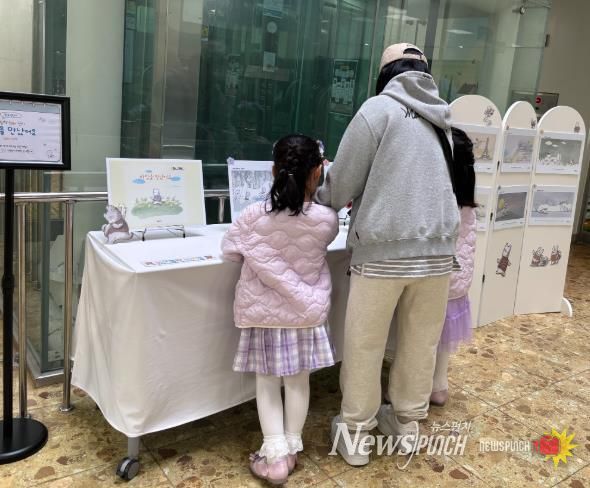 송정다가치문화도서관을 찾은 어린이와 시민들이 지난 3월 28일 도서관 1층 로비에 마련된 ‘열린 시선과 새로운 만남’ 그림책 원화 전시를 관람하고 있다.